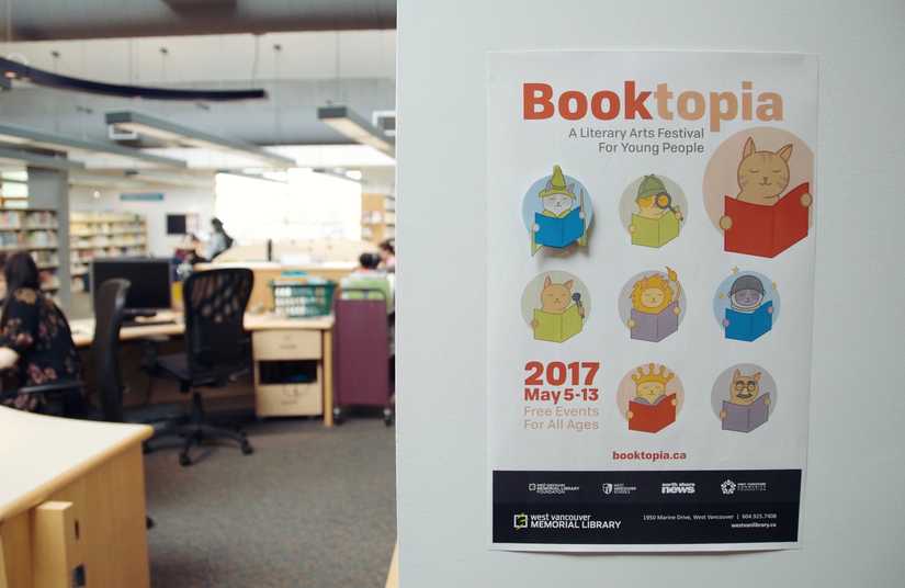 Photo of a Booktopia poster featuring all 10 cat icons on the wall in the West Van Library Youth section. 