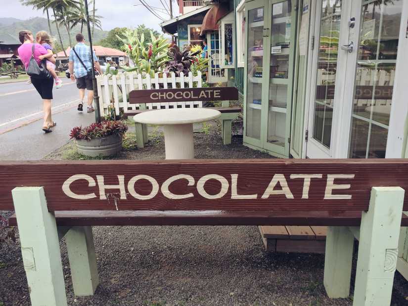 Benches at the front of a small building with "chocolate" painted across the top