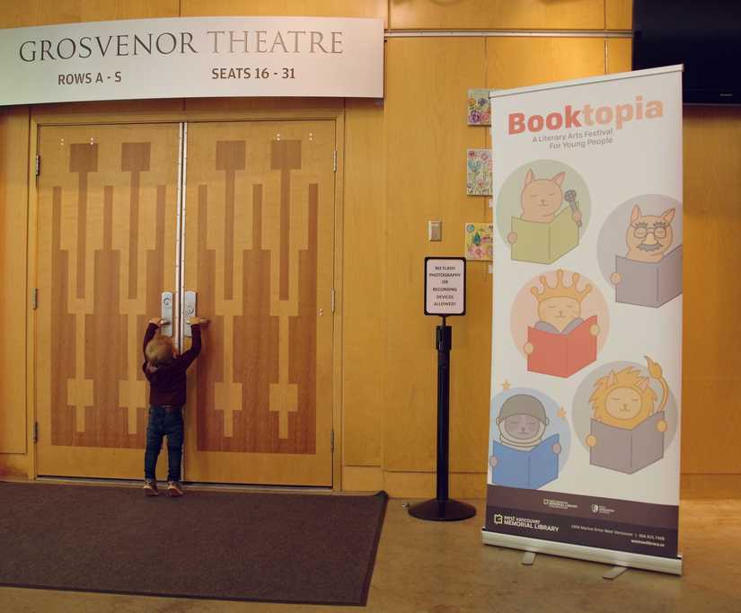A large pop up banner featuring the cat logos outside theatre doors.